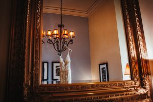 Peckforton Castle wedding, wedding dress hanging up with reflection in mirror