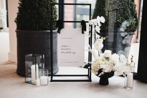 Wedding welcome sign hung on a black metal stand. Clean and elegant design.