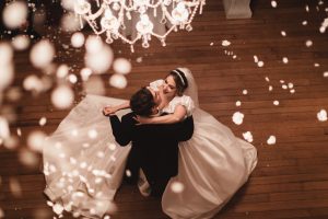 Bride and groom dancing with confetti falling down on them. Photo taken from above.