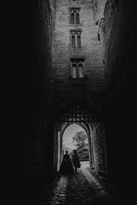 Black and white image of a bride and groom in the portcullis of Warwick Castle. Shortly after their wedding.