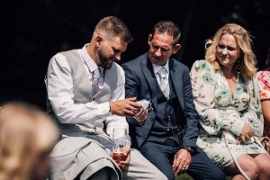 Wedding guests passing rings to each other in a wedding warming ceremony held at a wedding venue Lincolnshire. The sun is very bright.