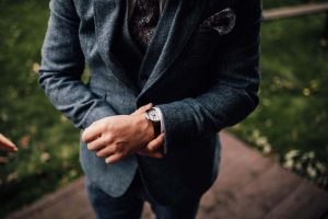 Groom looking at his watch. His face is not in the image.