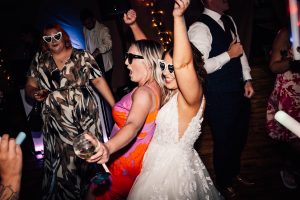 Bride in sunglasses on the dance floor, planning a wedding in 2024 dance floor inspiration