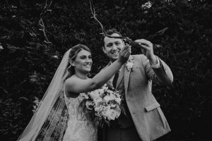 Bride and groom tiring a copper leaf to a tree on their wedding day.